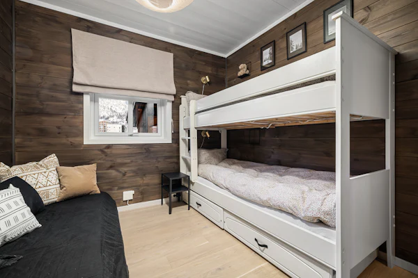 Bunk room with a white bunk bed, a trundle, and a daybed